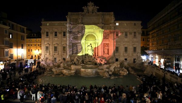 Цвета бельгийского флага на фасаде фонтана Треви в память о жертвах терактов. Рим, Италия