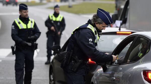 Полицейские досматривают автомобиль на подъезде к аэропорту в Брюсселе, Бельгия. 23 марта 2016