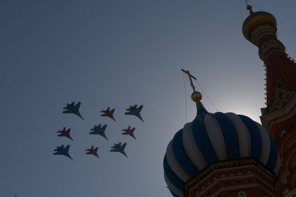 Истребители Су-27 пилотажной группы Русские витязи и МиГ-29 пилотажной группы Стрижи пролетают над Красной площадью