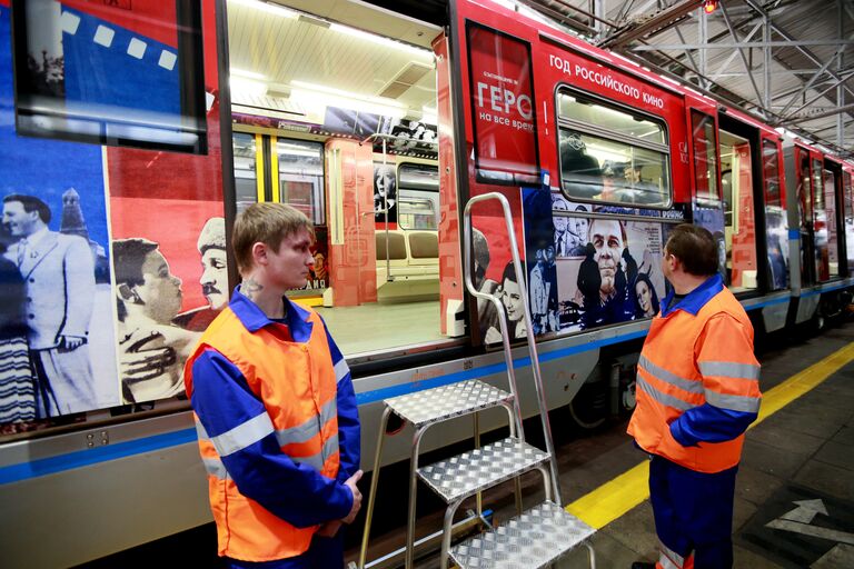 Сотрудники московского метрополитена рассматривают поезд Герои на все времена