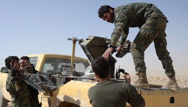 Бойцы отряда народного ополчения Соколы пустыни грузят пулеметную турель на автомобиль в районе сирийского города Пальмира