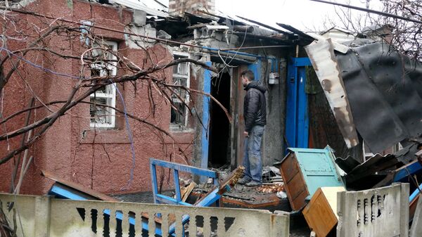 Мужчина у дома, поврежденного в результате обстрела украинскими силовиками, в Макеевке. Архивное фото