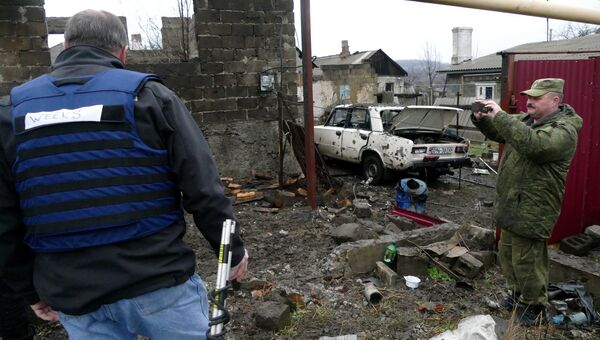 Мужчины на территории жилого дома, поврежденной в результате обстрела украинскими силовиками, в Макеевке. Архивное фото