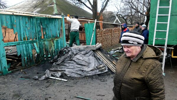 Женщина идет мимо двора жилого дома, пострадавшего в результате обстрела украинскими силовиками, в Макеевке