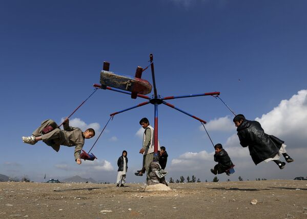 Афганские мальчики катаются на карусели во время празднования афганского Нового года в Кабуле