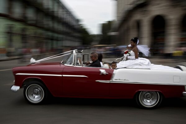 Американский классический автомобиль везет невесту на церемонию бракосочетания в Гаване, Куба