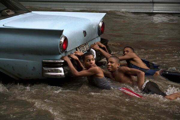 Дети играют во время наводнения в Гаване, Куба