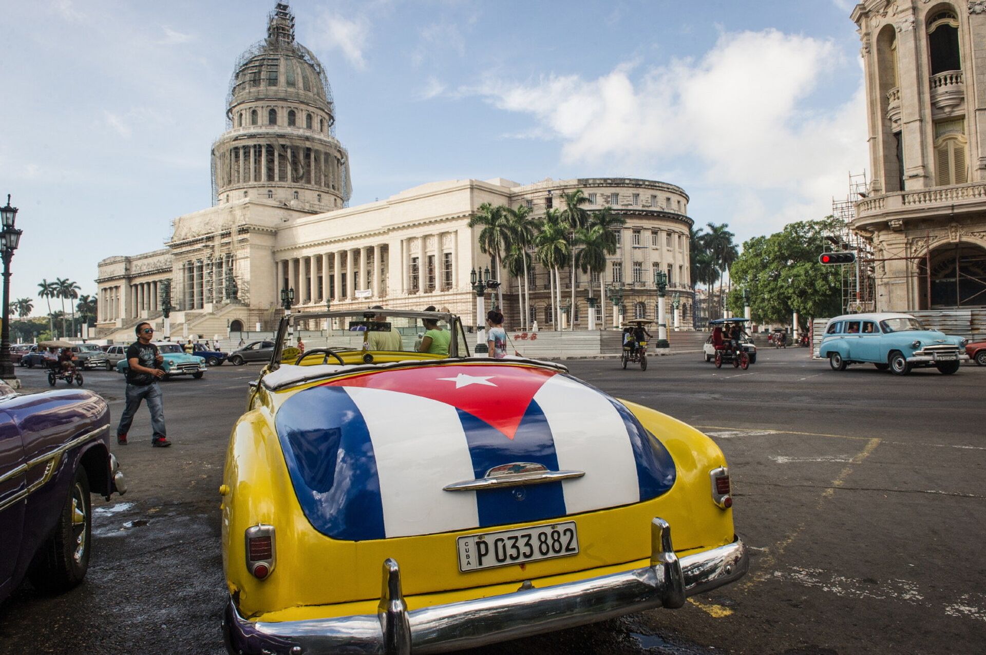Классический американский автомобиль с изображением кубинского флага возле здания Капитолия в Гаване, Куба - РИА Новости, 1920, 19.01.2022