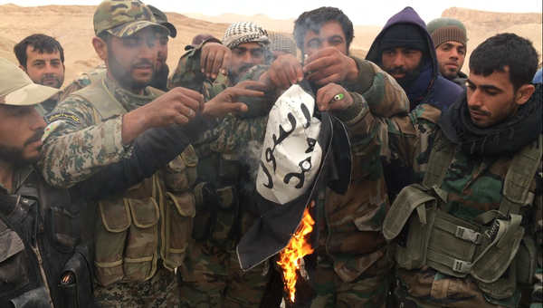 Сирийские солдаты сжигают флаг террористической группировки Исламское государство. Архивное фото