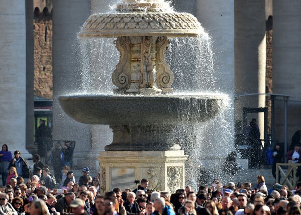 Верующие возле фонтана на площади Святого Петра перед началом мессы в Пасхальное воскресенье, Ватикан