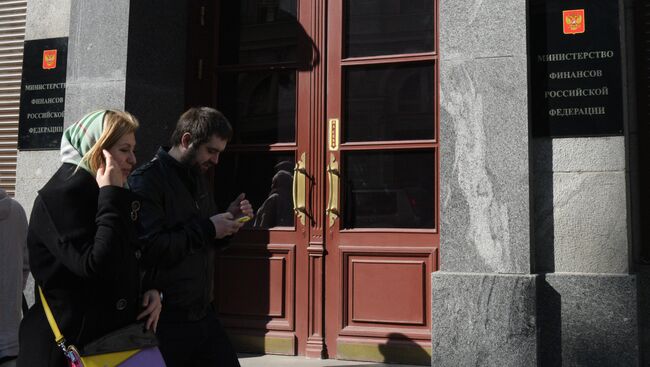 Прохожие у здания министерства финансов России на улице Ильинке в Москве