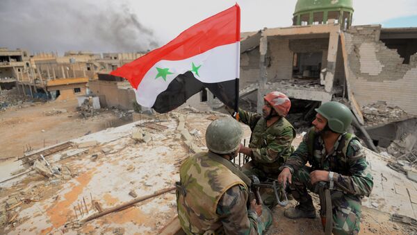 Солдаты сирийской армии (САА) с флагом Сирии радуются освобождению Пальмиры. Архивное фото