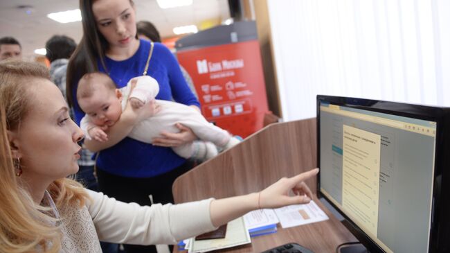 Сотрудница и посетительница центра государственных услуг в Москве. Архивное фото