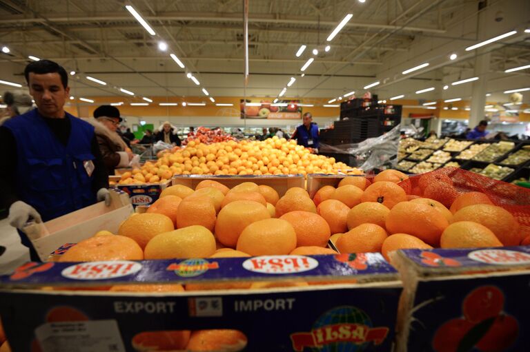 Продавец у прилавка с мандаринами из Турции Продавец у прилавка с мандаринами из Турции