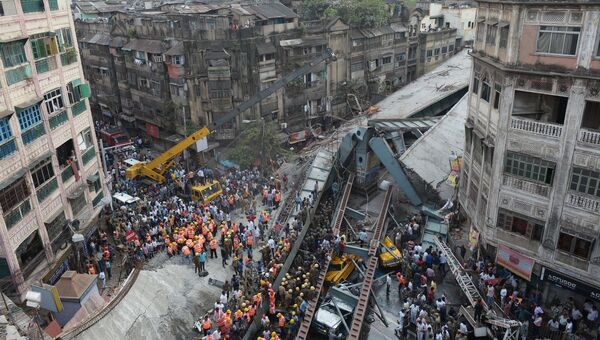 Индийские спасатели и добровольцы пытаются освободить людей, оказавшихся под обломками рухнувшего пролет моста в Калькутте. Архивное фото