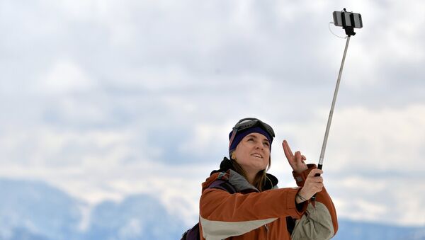 Девушка фотографируется на склоне горнолыжного курорта Роза хутор в Сочинском Национальном Парке