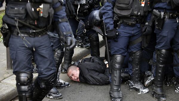 Полицейские задерживают участника манифестации в Париже, Франция. 5 апреля 2016