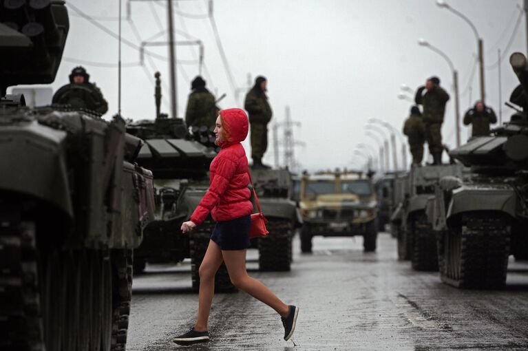Прохожая у танков, задействованных на репетиции парада Победы, в Екатеринбурге