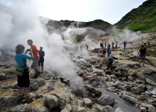 Туристы осматривают долину гейзеров на одном из склонов Мутновского вулкана