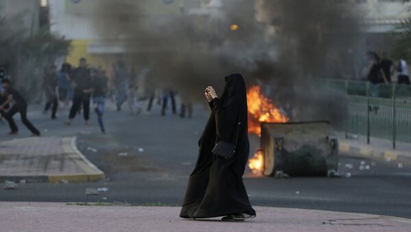 Жительница Бахрейна фотографирует сотрудников полиции во время антиправительственных демонстраций в Бахрейне. Архивное фото