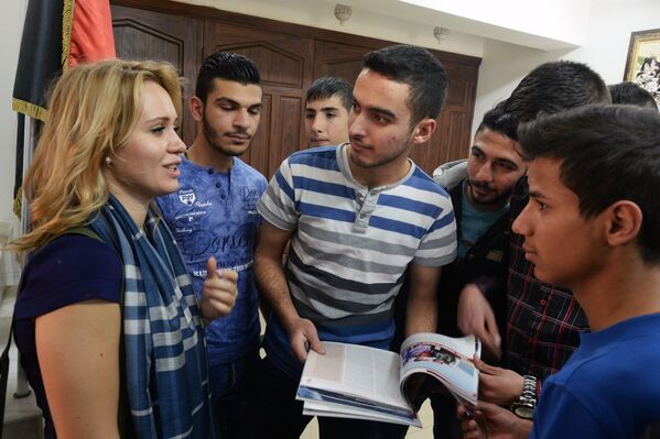 Представительница российской общественной организации Боевое братство разговаривает с учащимися во время посещения дамасской школы, где учатся дети погибших военнослужащих сирийской армии