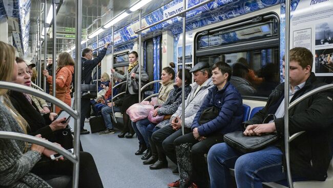 Пассажиры в поезде московского метрополитена, оформленного ко Дню космонавтики и посвященного 55-летию первого полета человека в космос. Архивное фото