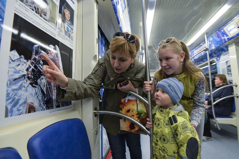 Пассажиры в поезде московского метрополитена, оформленного ко Дню космонавтики и посвященного 55-летию первого полета человека в космос