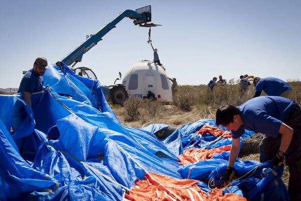 Члены команды Blue Origin возле капсулы экипажа после успешного полета и мягкой посадки в Западном Техасе. 2 апреля 2016