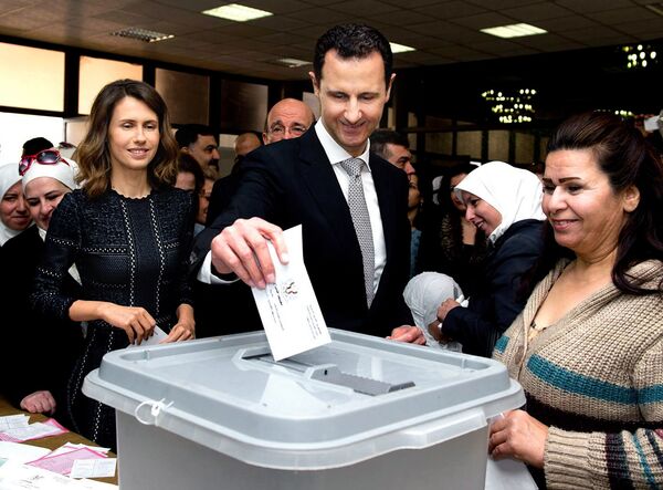 Президент Сирии Башар Асад и его супруга проголосовали на парламентских выборах на избирательном участке Асад в Дамаске