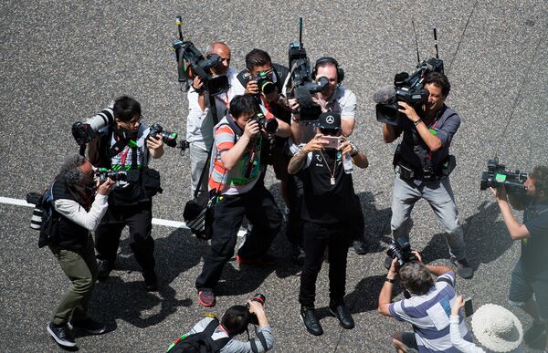 Британский гонщик Льюис Хэмилтон  делает селфи перед началом Гран-при Формула-1 в Китае