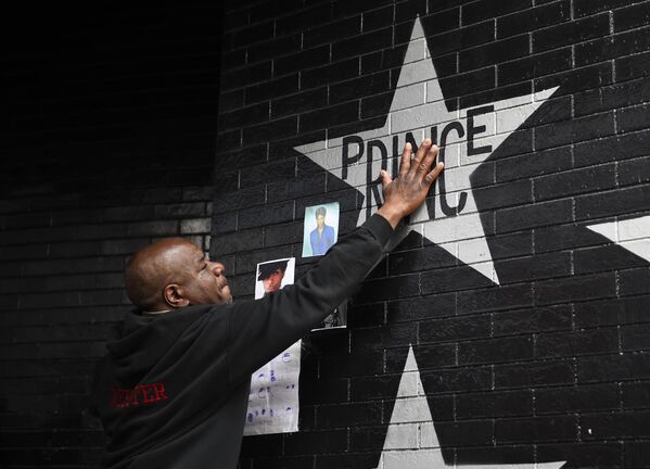 Поклонник возле звезды с именем Prince у клуба в Миннеаполисе, США