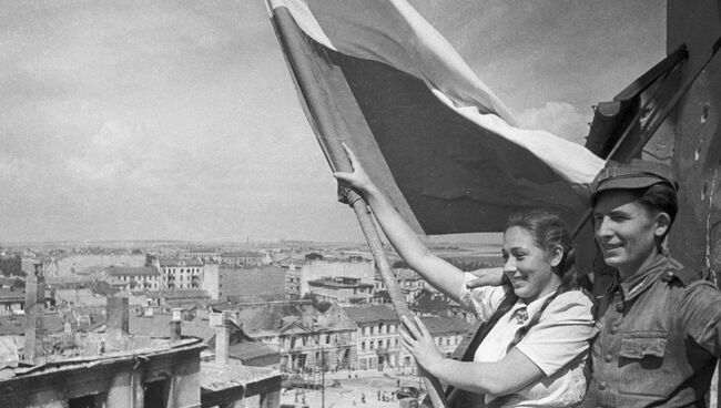 Молодые поляки поднимают флаг над освобожденным Люблином во время Великой Отечественной войны