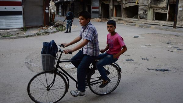 Мальчики едут на велосипеде по одной из улиц в Хомсе. Архивное фото