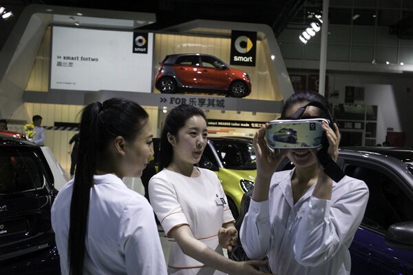 Модели на одном из стендов автосалона в Пекине. Апрель 2016