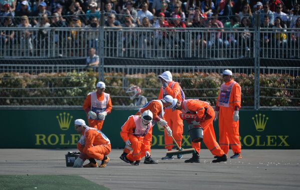 Маршалы собирают обломки болидов на трассе во время гонки на российском этапе чемпионата мира по кольцевым автогонкам в классе Формула-1