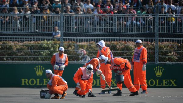 Маршалы собирают обломки болидов на трассе во время гонки на российском этапе чемпионата мира по кольцевым автогонкам в классе Формула-1
