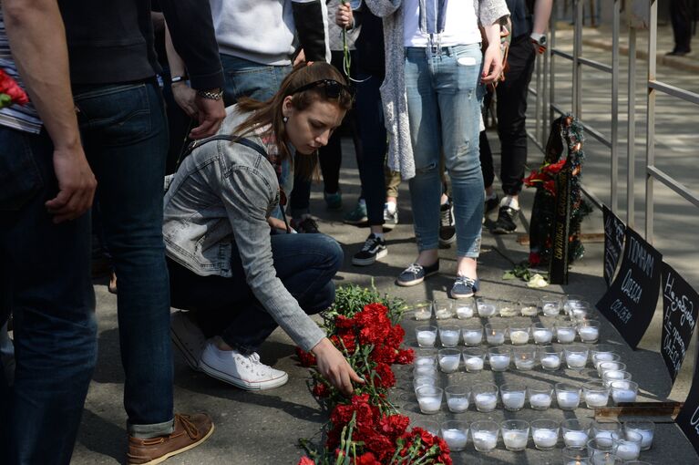 Девушка возлагает цветы во время акции в память о погибших при пожаре в одесском Доме профсоюзов у посольства Украины в Москве