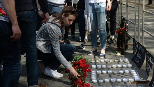 Девушка возлагает цветы во время акции в память о погибших при пожаре в одесском Доме профсоюзов у посольства Украины в Москве