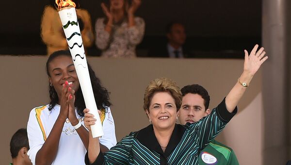 Президент Бразилии Дилма Русеф держит олимпийский факел. Май 2016