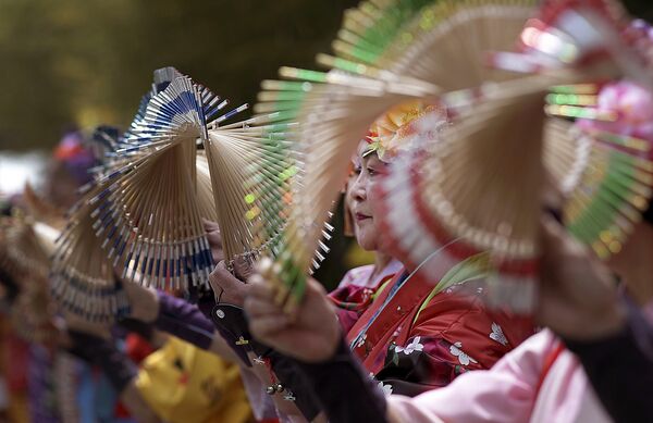 Артисты в традиционных костюмах во время уличного выступления в Токио, Япония