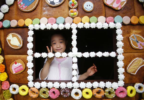 Девочка позирует в домике из конфет в одном из районов Токио, Япония