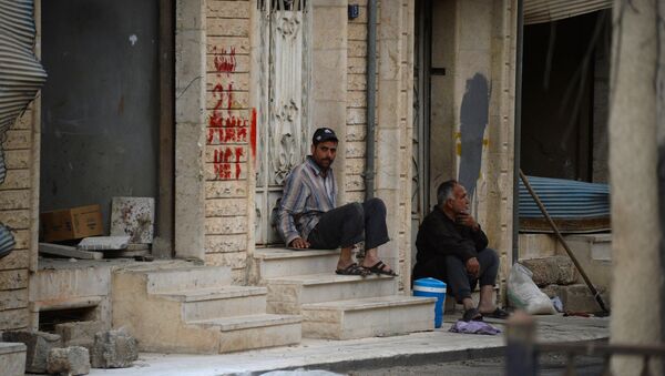 Мужчины сидят на крыльце дома на одной из улиц Сирии. Архивное фото