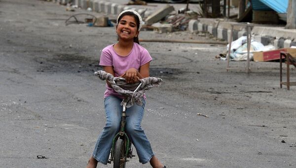 Девочка катается на велосипеде по одной из улиц Пальмиры