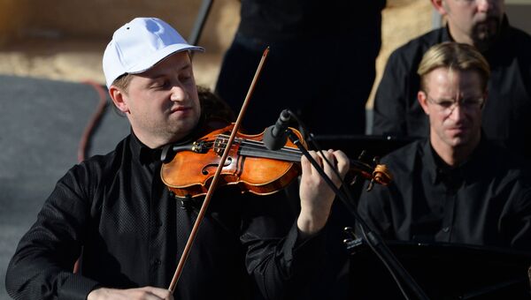 Скрипач Павел Милюков выступает на концерте симфонического оркестра петербургского Мариинского театра в Римском амфитеатре сирийской Пальмиры