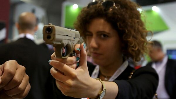 Женщина держит пистолет во время выставки SOFEX-2016 в Аммане, Иордания