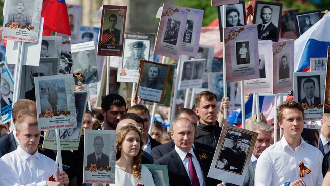 Президент России Владимир Путин (в центре) с портретом своего отца-фронтовика Владимира Спиридоновича принимает участие в шествии патриотической акции Бессмертный полк на Красной площади. Архивное фото