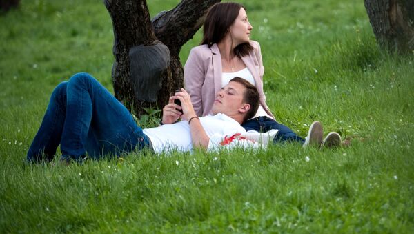 Молодые люди отдыхают в парке. Архивное фото