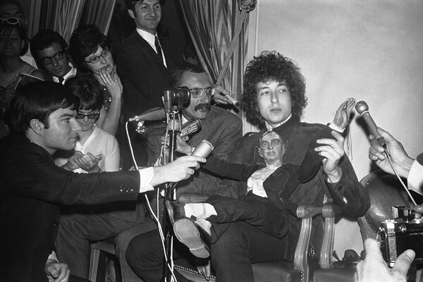Американский певец Боб Дилан с куклой во время пресс-конференции в отеле George V в Париже, Франция. 23 мая 1966