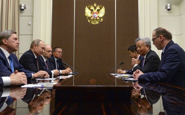 Президент Российской Федерации Владимир Путин (второй слева) и президент Азиатского банка инфраструктурных инвестиций Цзинь Лицюнь (второй справа) во время беседы в резиденции Бочаров ручей в Сочи