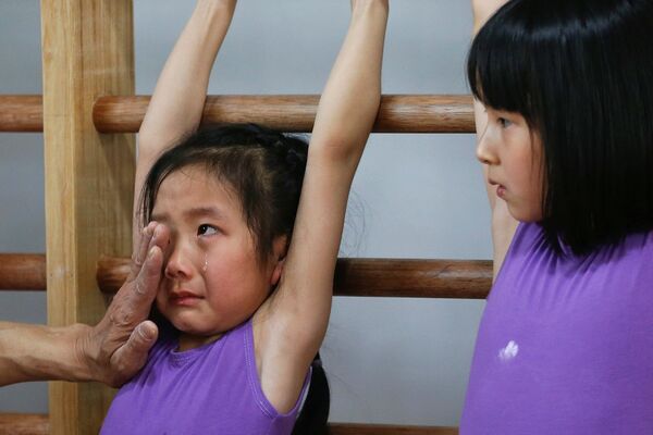 Тренер успокаивает ученицу спортивной олимпийской школы во время занятий. Шанхай, Китай